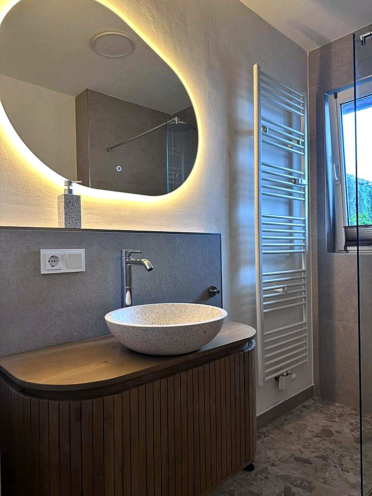 Badkamer met douche en ronde spiegel, vakantieappartement Dölsach